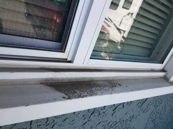Window track and sill with built-up dirt before detailing